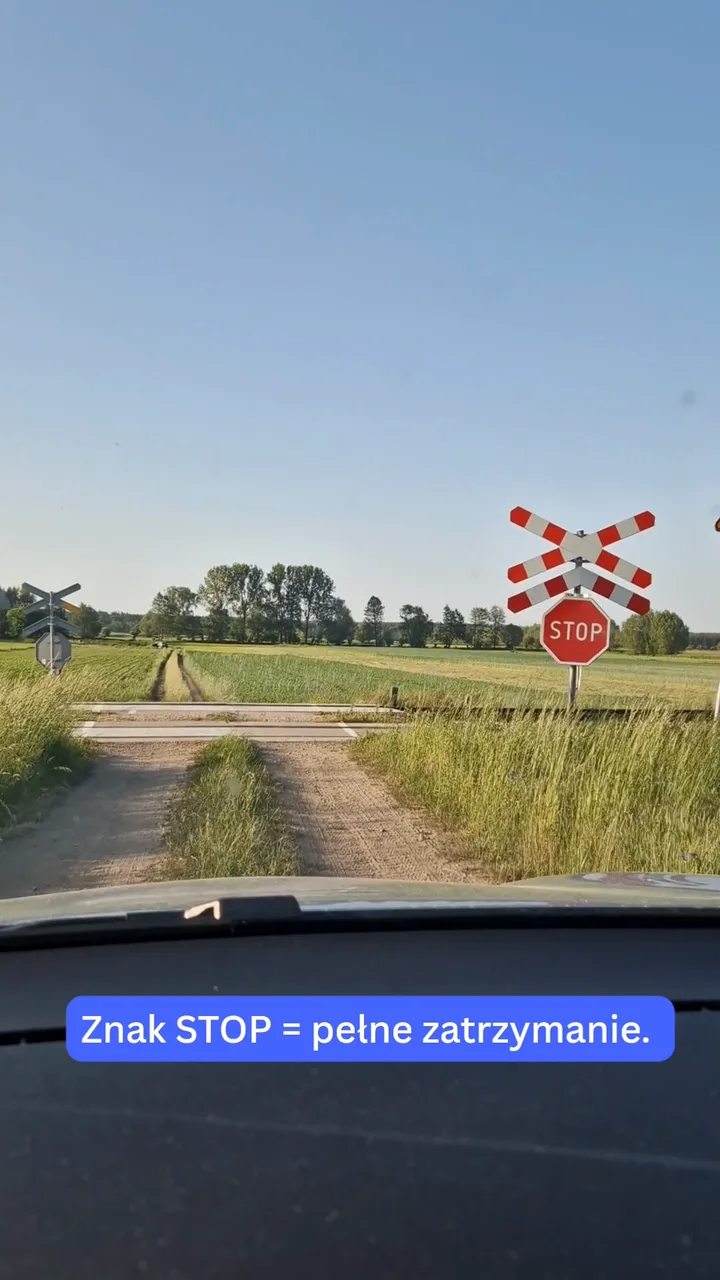 Przejazd kolejowo-drogowy bez rogatek ze znakiem STOP i krzyżem świętego Andrzeja, widok z fotela kierowcy.